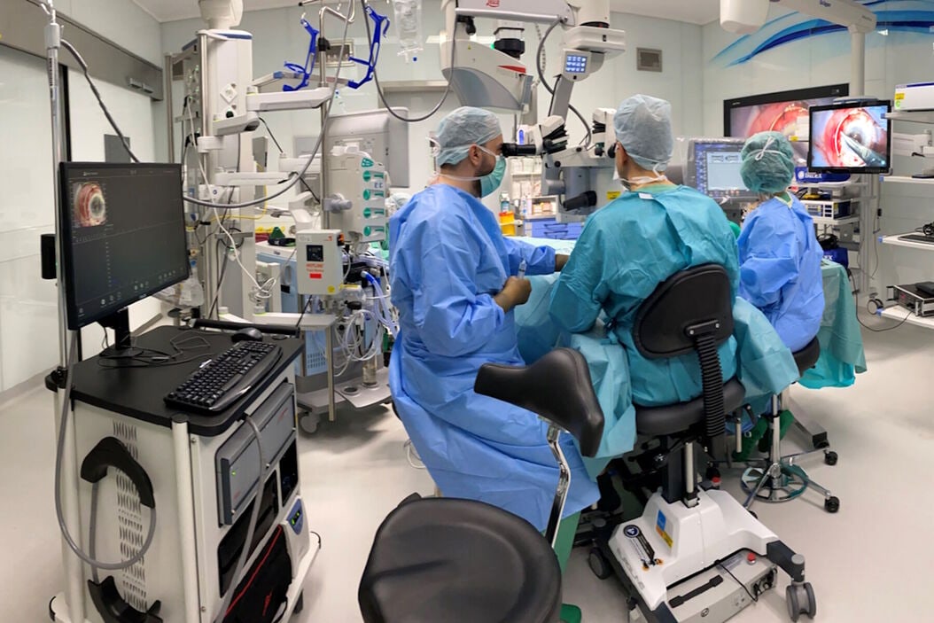 Ophthalmic surgery team working with microscope and surgical monitors in an operating room